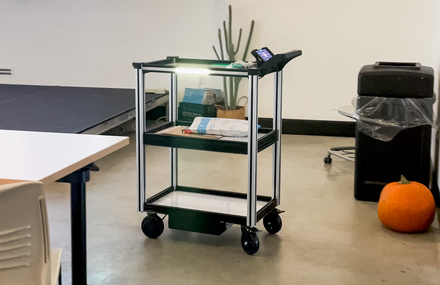 Model C2 autonomous cart seen transporting material like a package within a school classroom environment with desks and a projector.